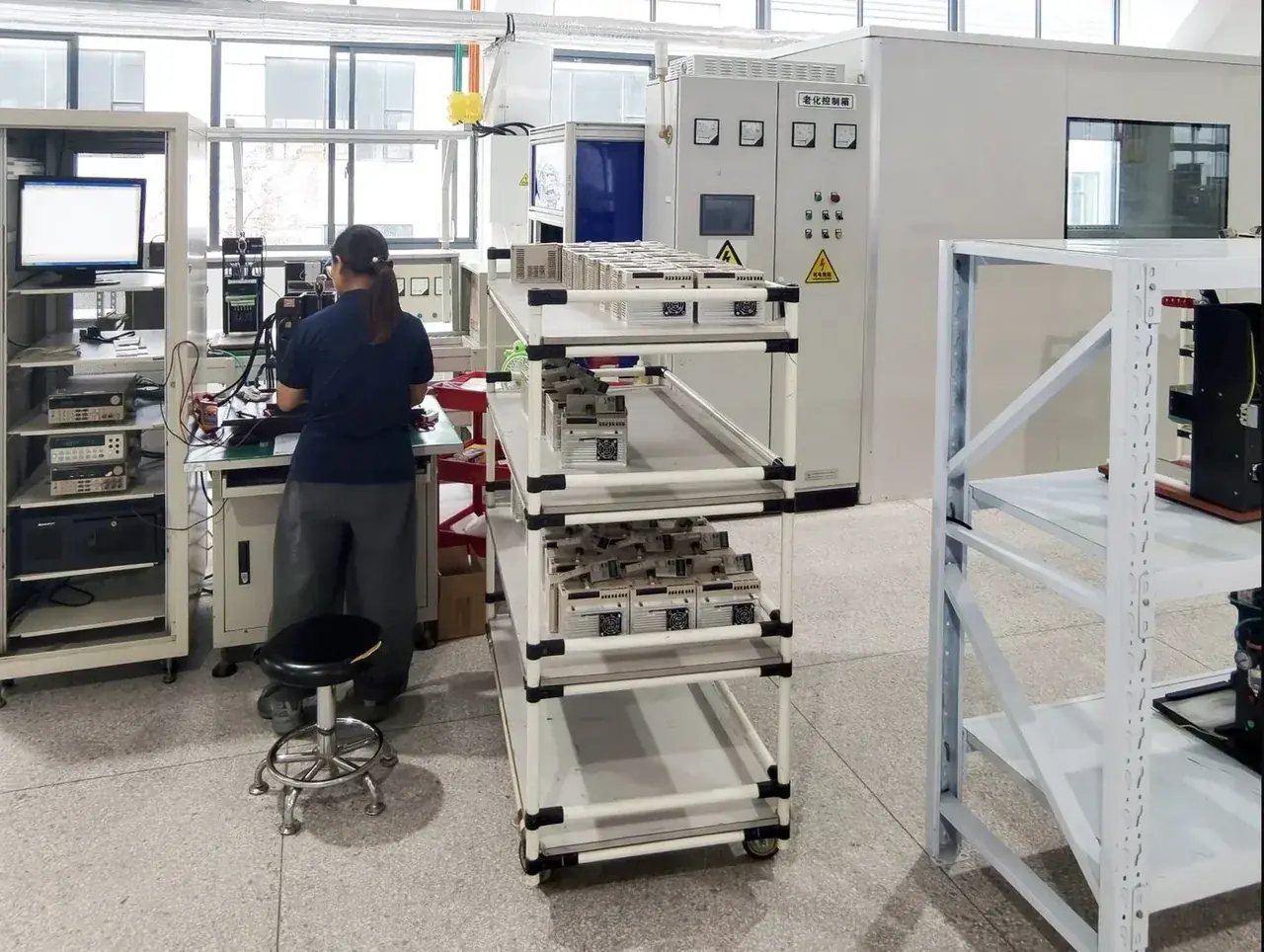 Drives on burn-in test racks with a technician at the monitoring console